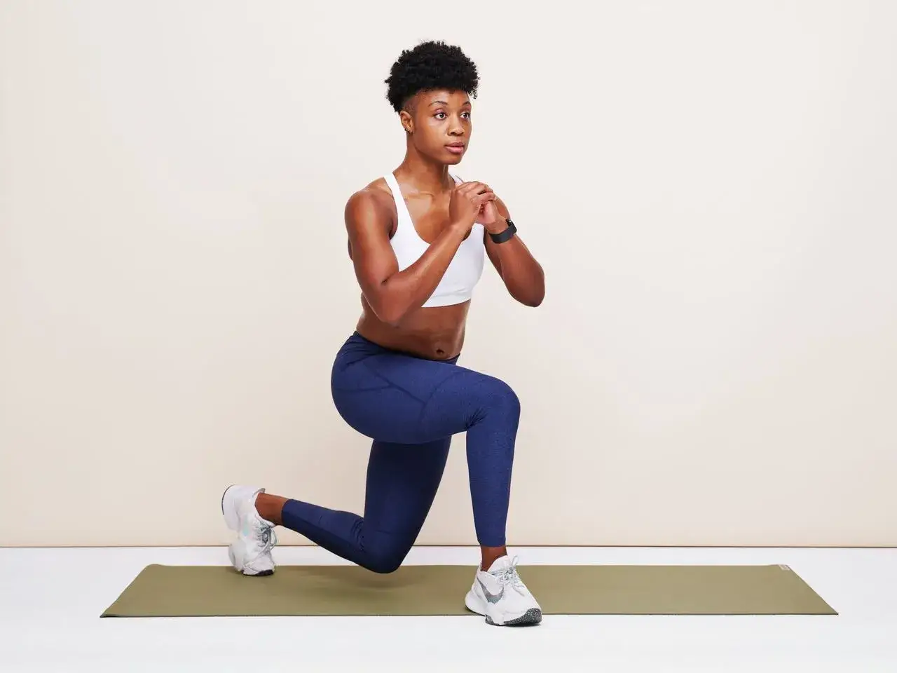 Frau macht Ausfallschritte für ein effektives HIIT Training zuhause.